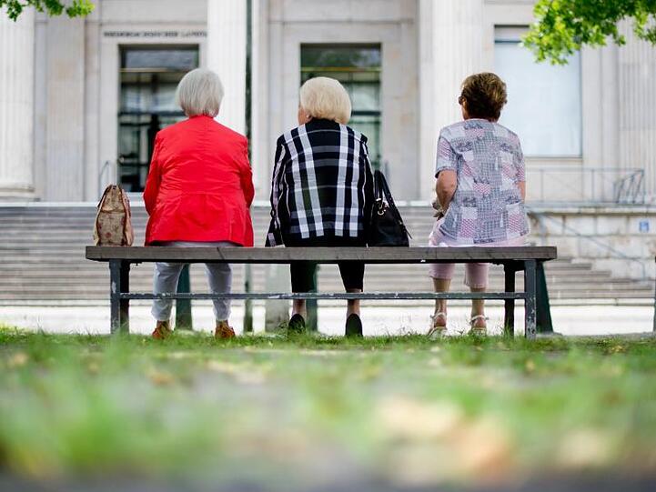 Drei ältere Frauen sitzen auf einer Bank. Foto: Julian Stratenschulte/dpa/archiv