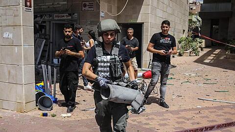 Ein Mitglied der israelischen Sicherheitskräfte hat die Überreste einer palästinensischen Rakete eingesammelt.