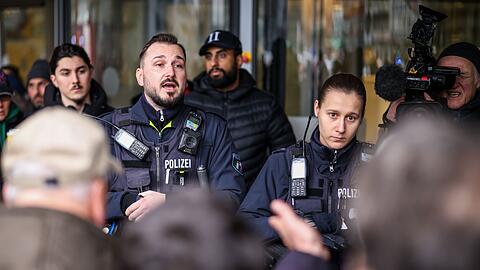 Polizeibeamte sprechen mit m&ouml;glicherweise betroffenen Kunden der Sparkassenfiliale in Buer.