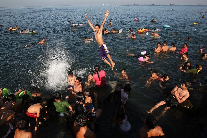 Auf den Philippinen schwimmen die Bewohner am Ostersonntaf im Wasser vom Manilaer Hafen. Damit feiern sie die Widergeburt Jesus Christus.