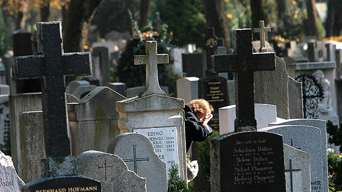Eine Frau trauert am Ostfriedhof München.