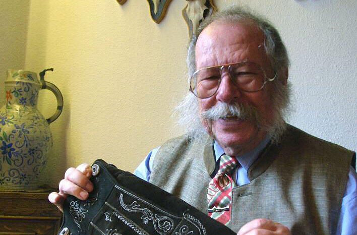In der Hand eine seiner Lederhosen, an der Wand allerlei Geweih: Dieses AZ-Foto von 2001 zeigt den Säcklermeister Erich Moser mit weißem Zauselbart in seiner Werkstatt in Deisenhofen. Am Samstag ist er im Alter von 90 Jahren gestorben.