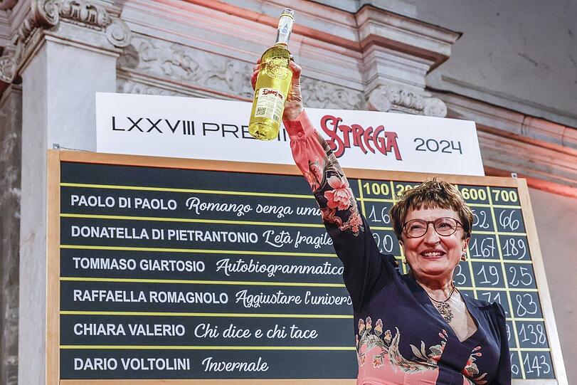Bei der Vergabe des großen italienischen Literaturpreises, des Premio Strega: Die Gewinnerin 2024, Donatella Di Pietrantonio, mit der Trophäe - einem"Hexenlikör".