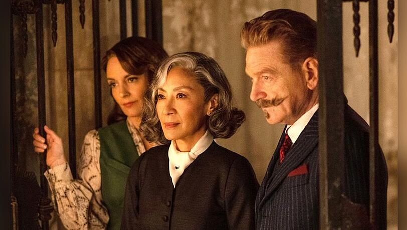 "A Haunting in Venice": Ariadne Oliver (Tina Fey, l.), Mrs Reynolds (Michelle Yeoh, M.) und Hercule Poirot (Kenneth Branagh).