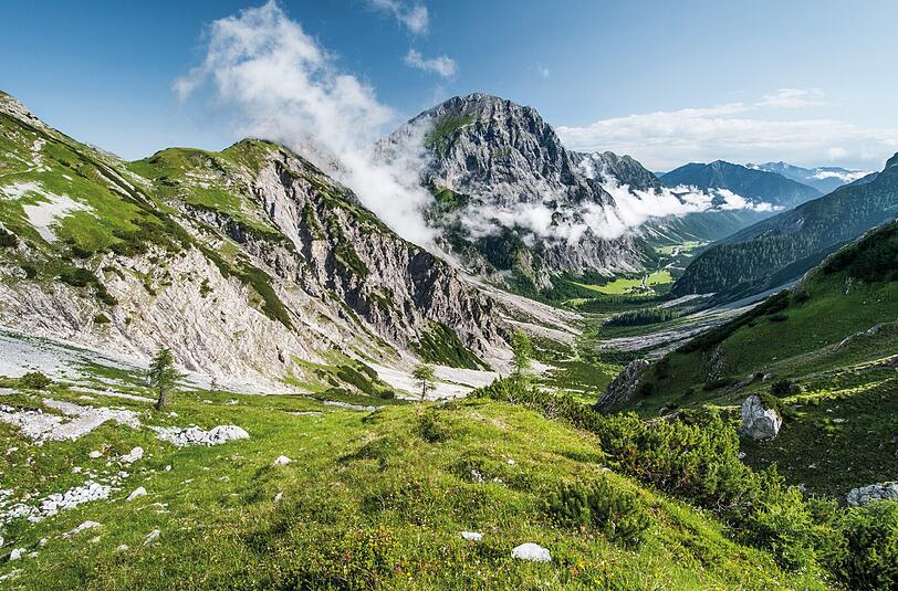 Lange Täler wie das Falzthurntal, das sich über insgesamt neun Kilometer erstreckt, gehören zum Karwendelgebirge. Im zentralen hinteren Bereich des Bildes erhebt sich das markante Sonnjoch (2457 Meter hoch) über der Gramaialm.