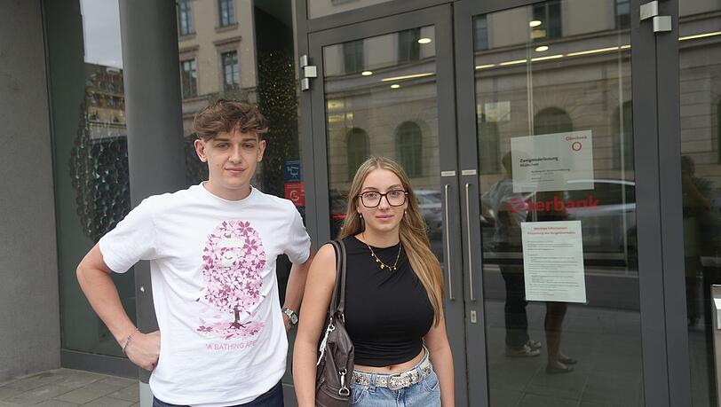 Kein Bargeld mehr: Christoph und Kiara stehen fassungslos vor der deutschen Niederlassung der Oberbank am Oskar-von-Miller-Ring in München. Kein Bargeld mehr: Christoph und Kiara stehen fassungslos vor der deutschen Niederlassung der Oberbank am Oskar-von-Miller-Ring in München.