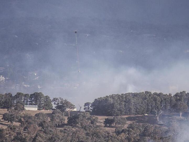 Ein Löschhubschrauber ist bei einem Buschfeuer in der Nähe der australischen Hauptstadt Canberra im Einsatz.