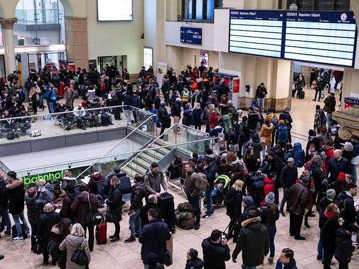 Reisende warten auf dem Hauptbahnhof in Hannover, dass der Zugverkehr wieder anläuft.