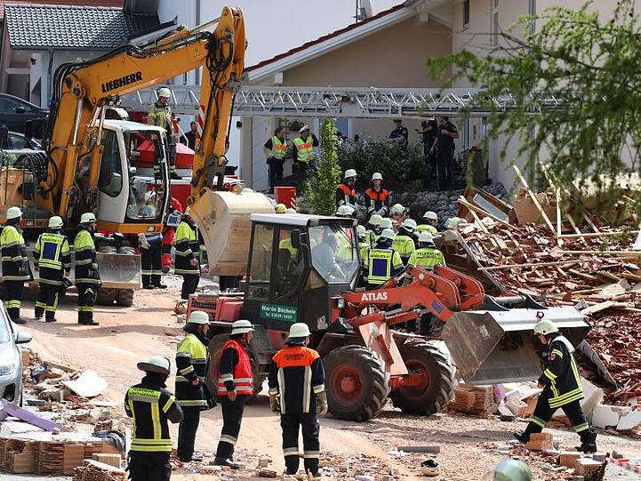 Einsatzkräfte räumen an einem zerstörten Haus Schutt beiseite. Foto: Karl-Josef Hildenbrand
