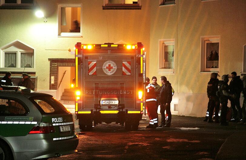 Spezialeinsatzkräfte der Polizei und Rettungssanitäter stehen in Weiden in der Oberpfalz vor einem Mehrfamilienhaus, in dem eine Frau bei einem Familienstreit schwer verletzt wurde.