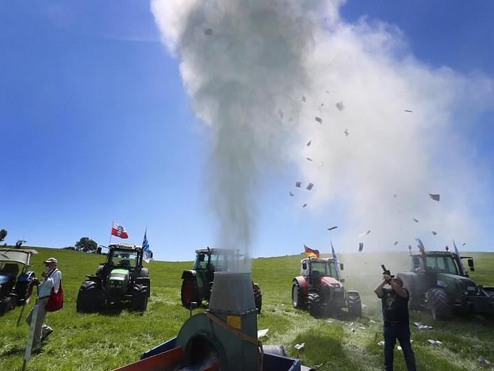 Milchpulver wird auf einer Protestaktion des Bundesverbandes der Deutschen Milchviehhalter die Luft geblasen. Foto: Karl-Josef Hildenbrand/dpa/Archivbild