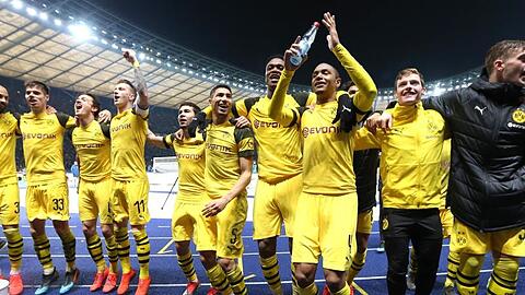 Die Spieler von Borussia Dortmund feiern den Last-Minute-Sieg in Berlin vor ihrer Fankurve.