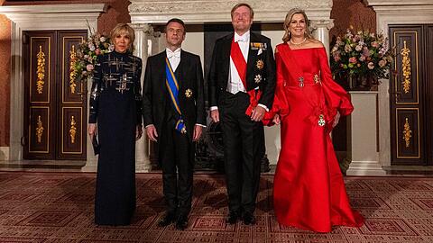 Neben dem französischen Präsidentenpaar und ihrem Mann sticht Königin Máxima in einem scharlachroten Kleid hervor.