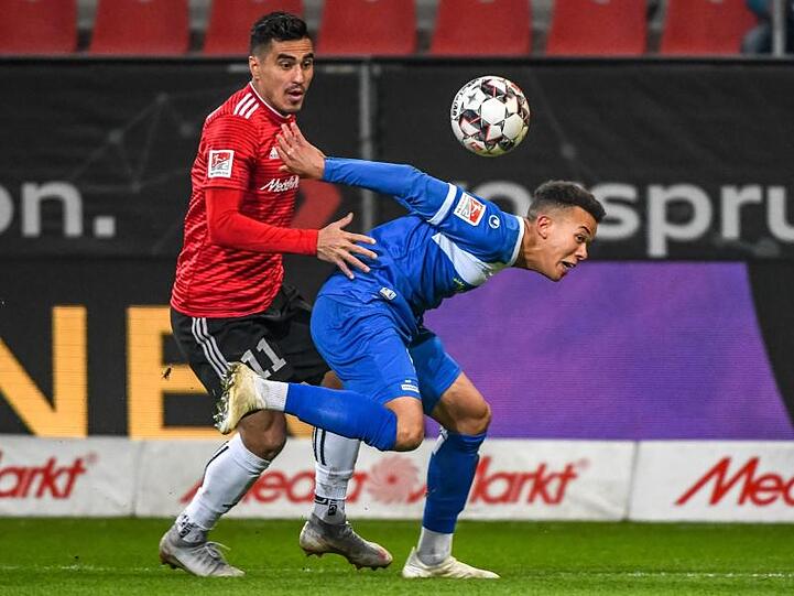 Darío Lezcano von Ingolstadt (l) und der Magdeburger Marcel Costly kämpfen um den Ball.