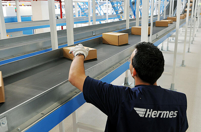 Ein Hermes-Mitarbeiter kontrolliert Päckchen. Foto: Uwe Zucchi/Illustration