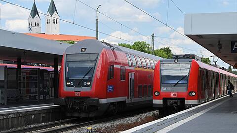 Züge stehen am Bahnhof in Freising. Im Hintergrund sind die Türme des Freisinger Doms zu sehen.