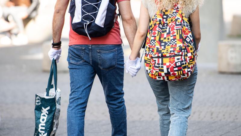 Ein Pärchen trägt während eines Einkaufsbummels auf der Schildergasse in Köln Schutzhandschuhe. Ein Pärchen trägt während eines Einkaufsbummels auf der Schildergasse in Köln Schutzhandschuhe.