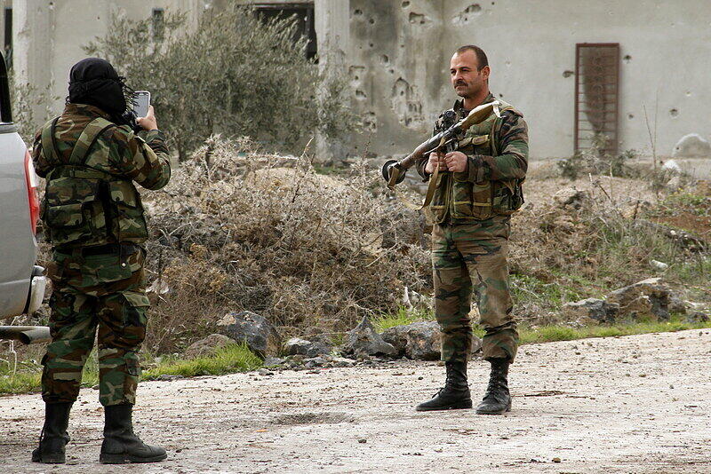 Ein syrischer Soldat macht am 11.02.2015 in Daraa, Syrien, ein Foto von einem Kameraden, der mit einer russischen Panzerbüchse vom Typ RPG-7 posiert.