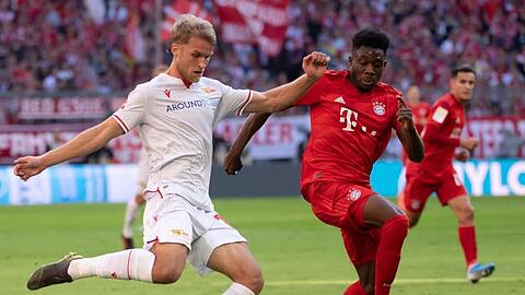 Sebastian Andersson von Berlin und Alphonso Davies von München (l-r.) kämpfen um den Ball. Foto: Sven Hoppe/dpa