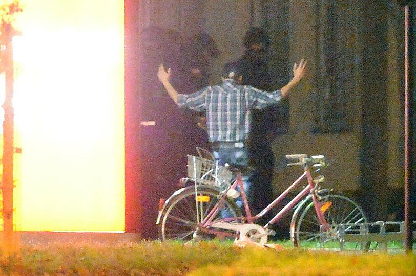 Mit erhobenen Händen kommt ein Mann auf die SEK-Beamten zu, im Hintergrund lauern Heckenschützen der Polizei. Die Beamten nehmen den Mann fest, es ist aber nicht der Täter, der sich in einem Imbiss in Freiburg veschanzt hat.