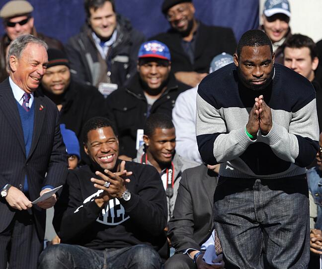Bürgermeister Michael Bloomberg mit den Giants Michael Strahan und Justin Tuck, der sich vor dem Publikum verneigt.