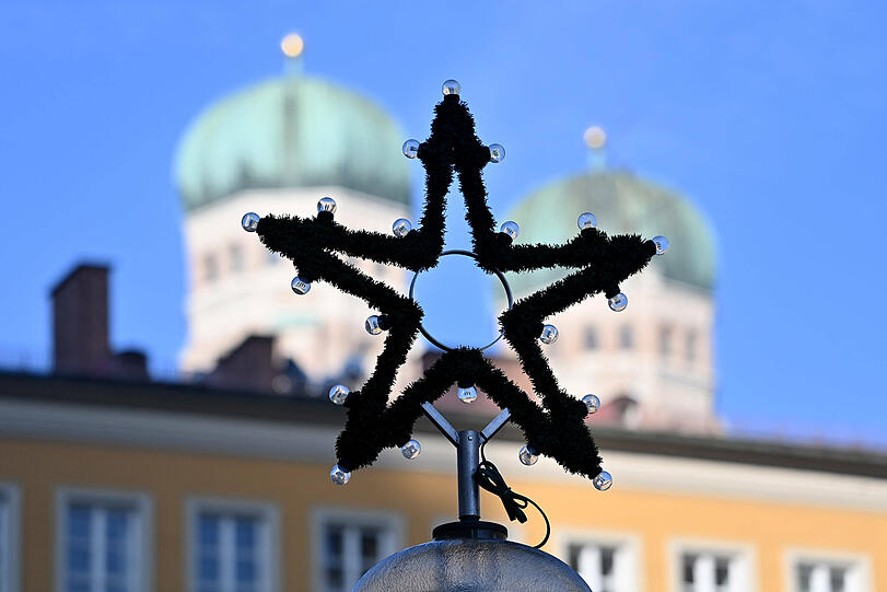 Ein Weihnachtsstern vor den Türmen der Frauenkirche.