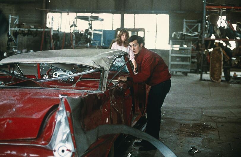 Arnie (Keith Gordon) und Leigh (Alexandra Paul) entdecken die völlig demolierte Christine in einer Werkstadt. Arnie (Keith Gordon) und Leigh (Alexandra Paul) entdecken die völlig demolierte Christine in einer Werkstadt.