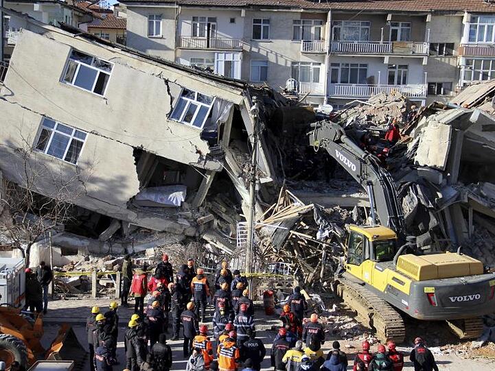 Rettungskräfte sind an einem eingestürzten Gebäude in Elazig im Einsatz.