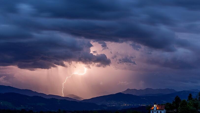Blitze entladen sich über den Alpen während eines aufziehenden Gewitters am Abend. Blitze entladen sich über den Alpen während eines aufziehenden Gewitters am Abend.