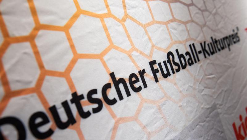 Der Schriftzug "Deutscher Fußball-Kulturpreis" ist auf einem Banner zu sehen. Foto: Nicolas Armer/dpa/Archivbild Der Schriftzug "Deutscher Fußball-Kulturpreis" ist auf einem Banner zu sehen. Foto: Nicolas Armer/dpa/Archivbild