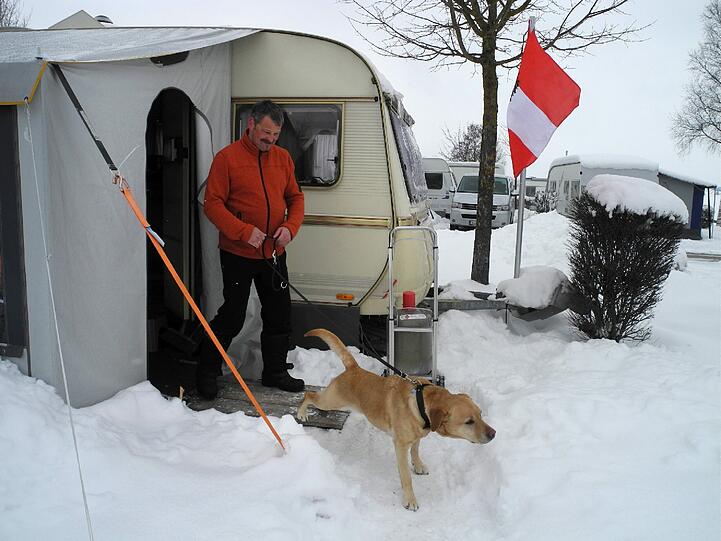 Lutz Müller auf einem Campingplatz in Brunnen im Schwangau (Bayern) mit seiner Hündin seinen Wohnwagen. Schon den dritten Winter verbringt Müller mit seiner Frau und Hündin Luna etwa zehn Wochen auf dem verschneiten Campingplatz direkt an den Alpen.