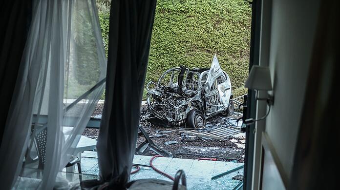 Ein ausgebranntes Auto steht nach einem Raketenangriff der Hamas vor einem beschädigten Haus in Ashkelon im Süden Israels. Ein ausgebranntes Auto steht nach einem Raketenangriff der Hamas vor einem beschädigten Haus in Ashkelon im Süden Israels.