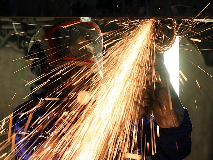 Ein Mitarbeiter eines Maschinenbauunternehmens schneidet Metallteile. Die Bestellungen bei Deutschlands Maschinenbauern gingen im April um 31 Prozent zurück.