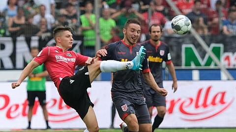 Hannovers Florent Muslija (l.) und Regensburgs Marco Grüttner kämpfen um den Ball. Foto: Peter Steffen