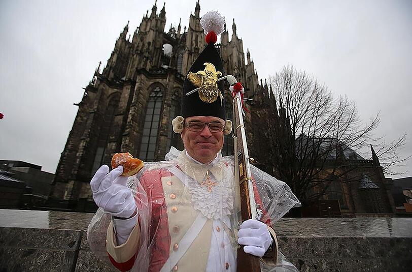 Dieses Mitglied der Karnevalsgesellschaft "Roten Funke" schützt mit Krapfen in der Hand den Dom vor Wildpinklern.