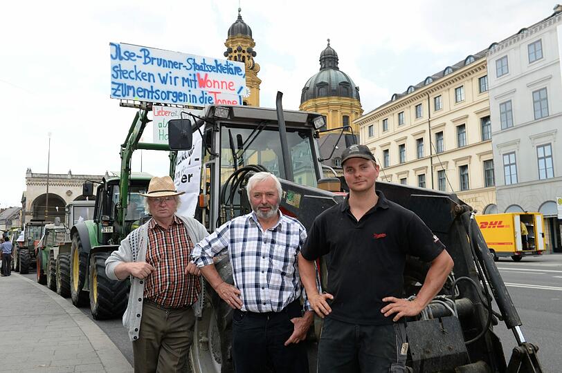 Die Bauern Alois Schmidt, (l-r), Peter und Andreas Bettele sind mit dem Traktor angereist.