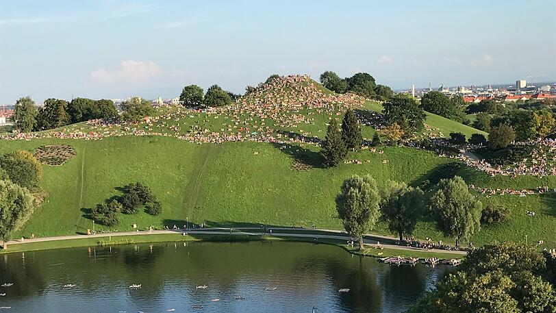 Fans, die kein Ticket für das Konzert bekommen haben, machen es sich auf dem Olympiaberg gemütlich. Dort ist die Musik aus dem Stadion sehr gut zu hören.