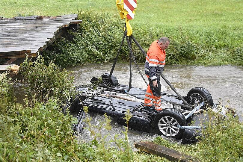 Bei Bayerischzell am Schliersee landet ein Passat kopfüber in einem stark überfluteten Bach. Der Fahrer kann in letzter Sekunde gerettet werden. Die Bilder des Unfalls.
