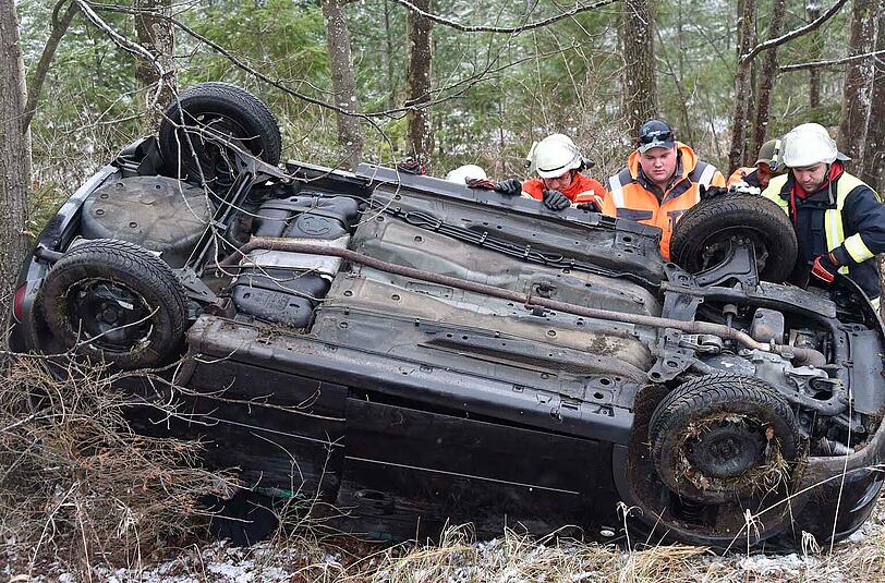 Die Einsatzkräfte aus Grasbrunn und Harthausen stellen das Autowrack wieder auf die Räder.