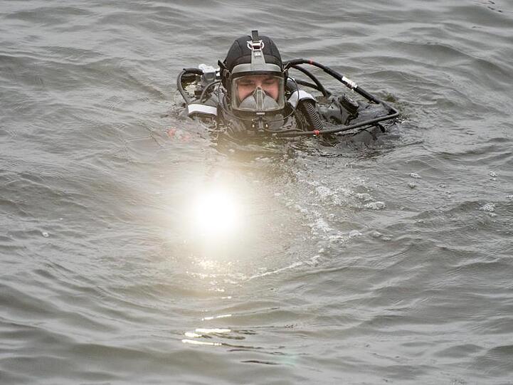 Ein Polizeitaucher schwimmt im Wasser. Foto: Daniel Reinhardt/Archivbild
