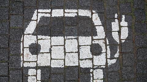 Ein Symbol markiert einen Parkplatz mit einer öffentlichen Ladesäule für Elektroautos in der Innenstadt von Hannover.