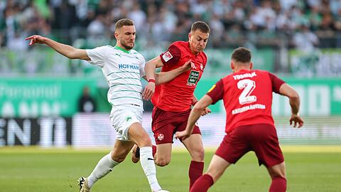 Der Fürther Dennis Srbeny (l) kämpft mit Filip Kaloc (M) und Boris Tomiak aus Kaiserslautern um den Ball.