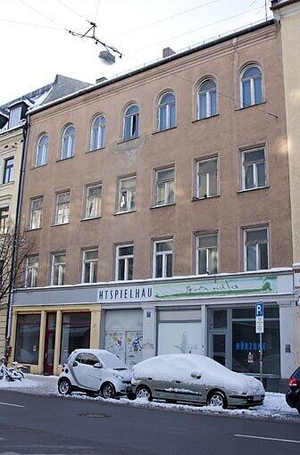 Die Fassade des Hauses bröckelt, auf dem Dach wachsen Sträucher.