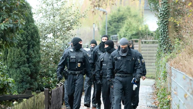 Mehrere vermummte Polizisten gehen an einem Haus entlang. Foto: Christian Butt/TNN/Archiv Mehrere vermummte Polizisten gehen an einem Haus entlang. Foto: Christian Butt/TNN/Archiv