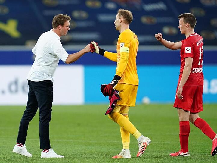 Leipzigs Trainer Julian Nagelsmann (l) klatscht sich nach dem Sieg mit Torwart Peter Gulacsi (M.) und Lukas Klostermann ab.