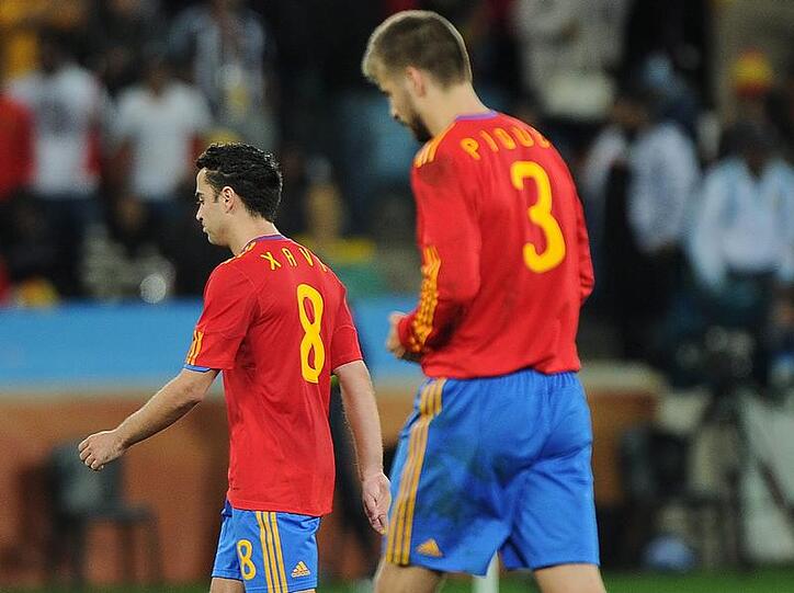 Die Spanier Gerard Pique (r) und Xavi verlassen nach der Niederlage das Spielfeld.