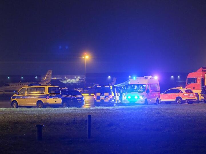 Fahrzeuge von Einsatzkräften stehen auf dem Flughafen gegenüber vom Terminal A.