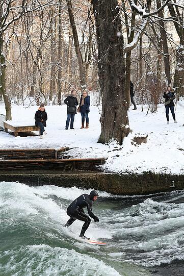 Ein Surfer im Neoprenanzug reitet auf der Welle im Eisbach hinter dem Haus der Kunst. 	Fotos (6): Sigi Müller