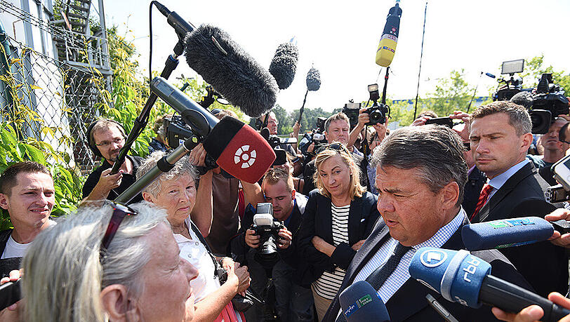 Bundeswirtschaftsminister Sigmar Gabriel (M) wird in Heidenau von Journalisten umringt. Bundeswirtschaftsminister Sigmar Gabriel (M) wird in Heidenau von Journalisten umringt.