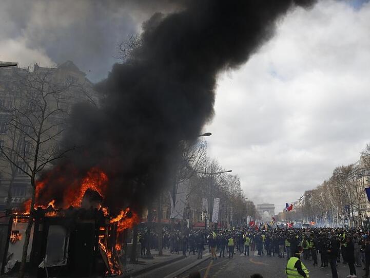 Ein Kiosk steht auf den Champs-Elysees in Flammen.